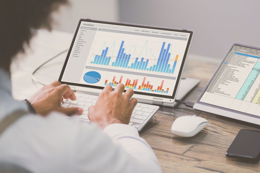 person working on laptop with graphs on the screen
